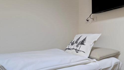 a white bed with a pillow with palm trees on it at Domus MEA - Breakfast Included! in San Martino Buon Albergo