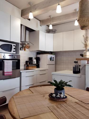une cuisine avec des armoires blanches et une table en bois dans l'établissement Chez Camille & Olivier, chambres, à Esparron-de-Verdon