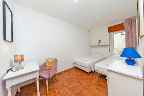 a small room with a bed and a desk with a lamp at Rising Sun Apartments in Lagos