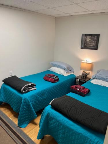 two beds in a room with blue and black sheets at Art Gallery Hostel in Whitefield