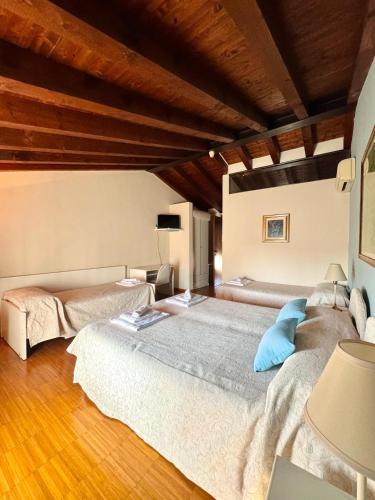 two beds in a room with wooden ceilings at Locanda al Caminetto in Monzambano