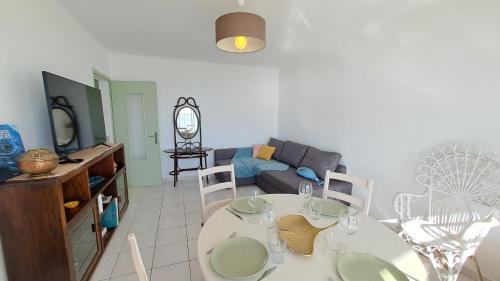 un salon avec une table et un canapé dans l'établissement AIGUE MARINE - Appartement Vue Mer 1 chambre, à Saint-Jean-de-Monts