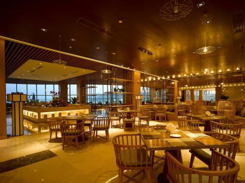 a restaurant with tables and chairs and a bar at Harman Resort Hotel Sanya in Sanya