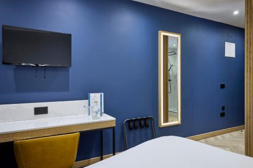 a blue room with a bed and a mirror at Handel's Hotel in Dublin