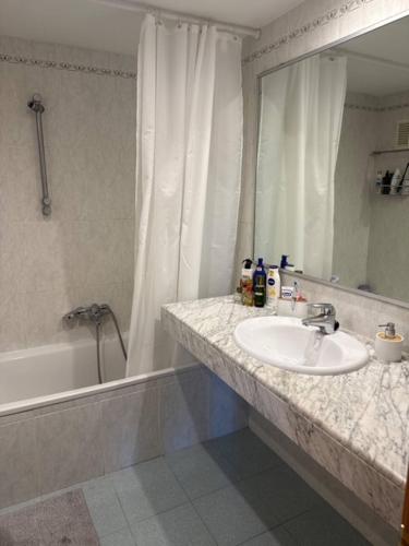 a bathroom with a sink and a shower and a mirror at Surf&Snooze in Castelldefels