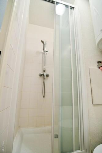 une douche avec une porte vitrée dans une salle de bain dans l'établissement Grange Blanche 1, à Lyon