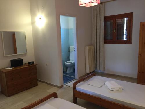 a bathroom with a bed and a toilet in a room at summer apartment in Almirida