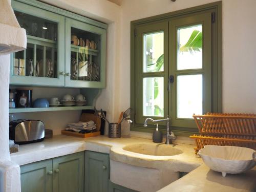 a kitchen with a sink and a window at Ochre Dream, Beach front & Sunset villa Naousa in Naousa