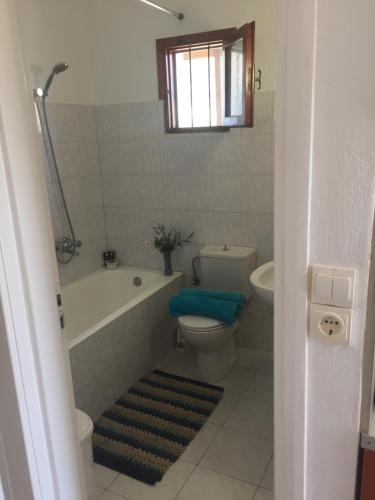 a bathroom with a tub and a toilet and a sink at summer apartment in Almirida