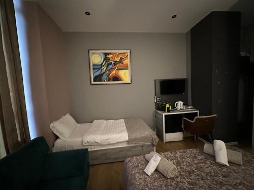 a bedroom with a bed and a desk with a television at Colombia Apartments&Rooms in Durrës