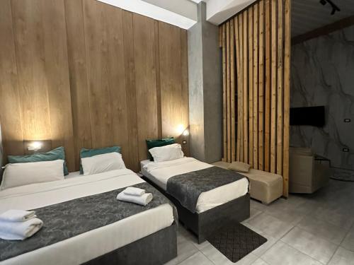 a hotel room with two beds and a television at Colombia Apartments&Rooms in Durrës