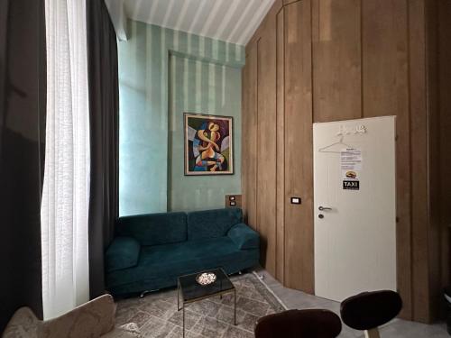a living room with a blue couch and a refrigerator at Colombia Apartments&Rooms in Durrës