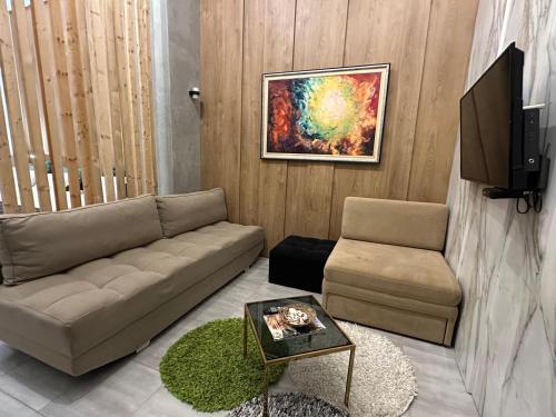a living room with a couch and a tv at Colombia Apartments&Rooms in Durrës