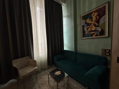 a living room with a green couch and a chair at Colombia Apartments&Rooms in Durrës