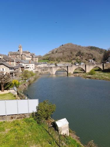 a bridge over a river in a town at La Minoterie du Lot in Estaing