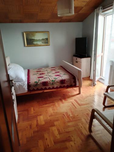 a bedroom with a bed and a television in it at Pokoje u Jolanty in Władysławowo