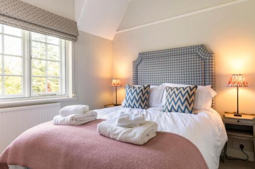 a bedroom with a large bed with towels on it at Laundry Cottage in High Legh