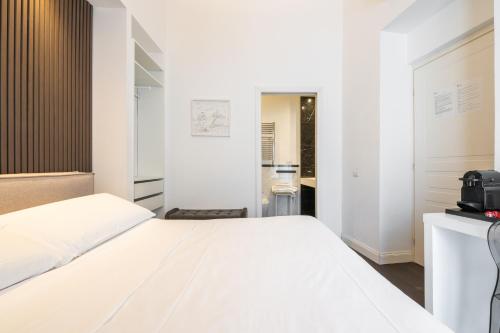 a bedroom with a white bed and a television at PLEY Cagliari Boutique Suites in Cagliari