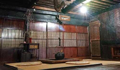 a room with wooden walls and a table with a pot at みのり家 - Samurai-era house - 昔の暮らし体験 in Takayama