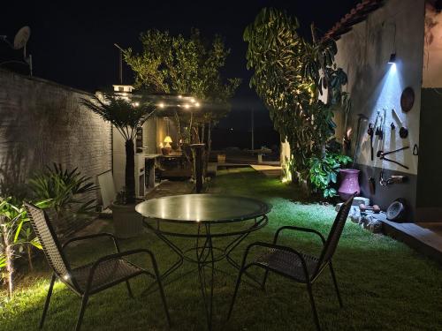 a patio with a table and chairs at night at Casa com vista exuberante in Pouso Alegre