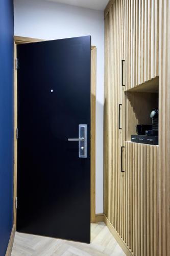 a black door in a room with a pantry at Handel's Hotel in Dublin