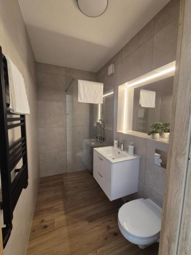 a bathroom with a white toilet and a sink at Pokoje pod Kamienną Bramą in Chojnice