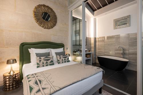 une chambre avec un lit et une baignoire et une baignoire dans l'établissement L'Atelier des Arts, à Paris