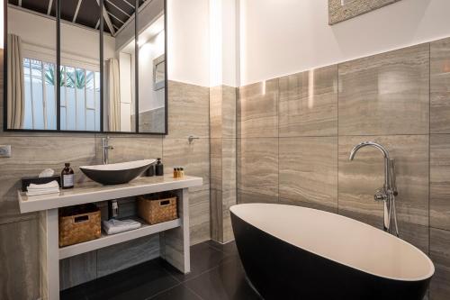 une salle de bain avec une baignoire et un lavabo dans l'établissement L'Atelier des Arts, à Paris