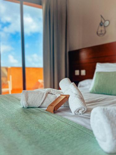 a hotel room with towels on a bed with a window at CN-340 Suites in Estepona