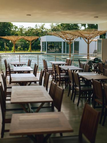an empty restaurant with wooden tables and chairs at Pipa Privilege Ocean Oficial in Pipa