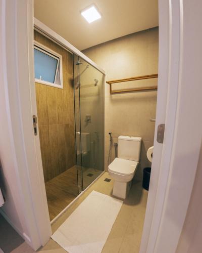 a bathroom with a toilet and a glass shower at Pipa Privilege Ocean Oficial in Pipa