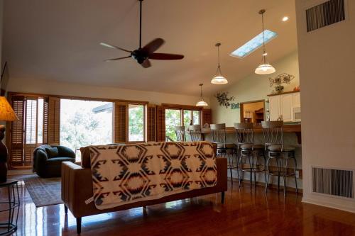 a living room with a couch and a ceiling fan at Hideaway Riverfront Cabin in Kernville with Universal EV Charger in Kernville