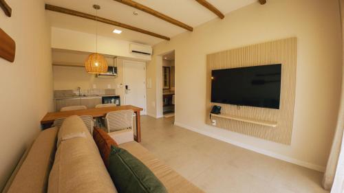 a living room with a couch and a television on a wall at Pipa Privilege Ocean Oficial in Pipa