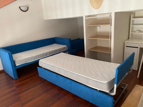 Cette petite chambre comprend un lit bleu et une étagère. dans l'établissement T4-72 m2 Vue Panoramique - 200 m de la plage - Etage 5 avec Ascenseur -6 pers max, à Sète