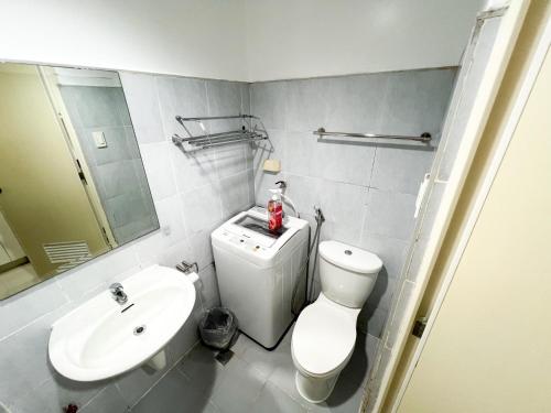 a bathroom with a white toilet and a sink at Sea Residences Navigators in Manila