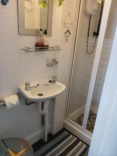 a bathroom with a sink and a shower at Marjune Guest House in Weymouth