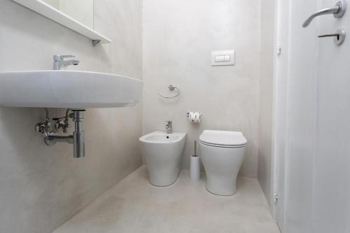 a white bathroom with a sink and a toilet at L'uomo e il mare by Inside Salento in Gallipoli