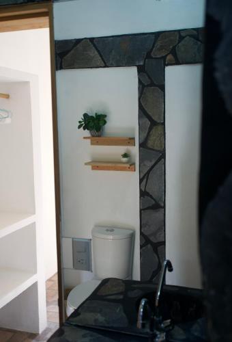 a bathroom with a toilet and a sink and a mirror at Casa Lucy Oaxaca in San Pedro Pochutla