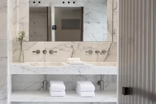 a white bathroom with a sink and a mirror at Mandarin Oriental Lutetia, Paris in Paris