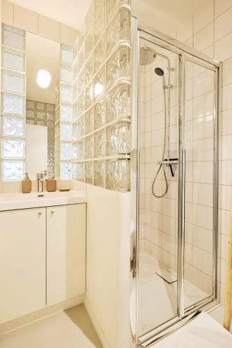 une salle de bain avec douche et lavabo dans l'établissement Grand studio pour 4p Paris 14, à Paris