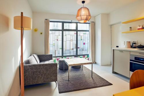 un salon avec un canapé et une table dans l'établissement Grand studio pour 4p Paris 14, à Paris