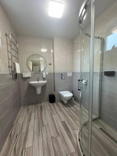 a bathroom with a shower and a sink and a toilet at Guest House Zatyshnyi Dvir in Bukovel