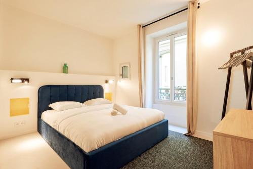 une chambre avec un lit bleu et une fenêtre dans l'établissement Grand studio pour 4p Paris 14, à Paris
