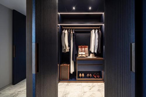 a walk in closet with blue walls and a black door at Mandarin Oriental Lutetia, Paris in Paris
