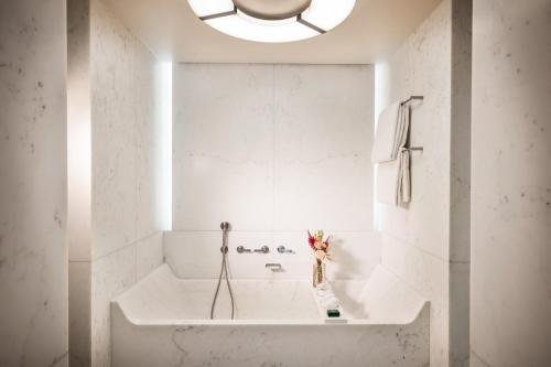 a white bathroom with a tub and a sink at Mandarin Oriental Lutetia, Paris in Paris