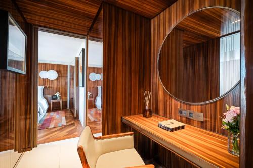 a room with a mirror and a desk with a chair at Mandarin Oriental Lutetia, Paris in Paris