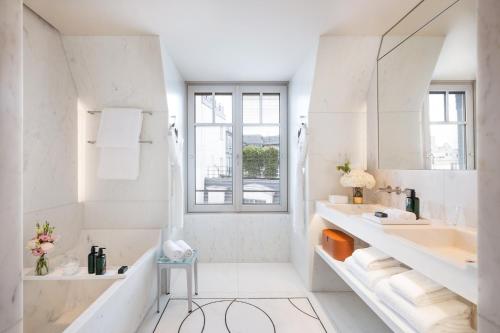 a white bathroom with a sink and a mirror at Mandarin Oriental Lutetia, Paris in Paris