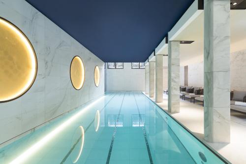 a swimming pool in a building with a blue ceiling at Mandarin Oriental Lutetia, Paris in Paris