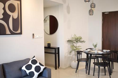 a living room with a table and a blue couch at Danga Bay 2BR 2WR - Black Or White - Walk to Beach in Johor Bahru