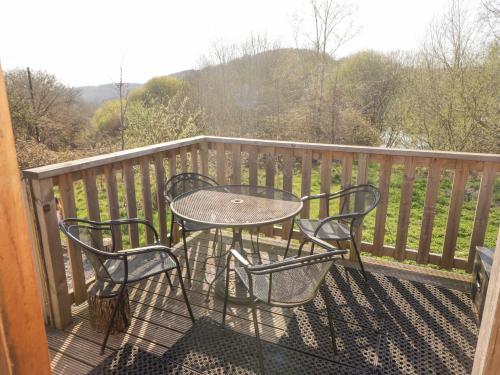 a table and two chairs on a balcony with a view at Cabanau Bach in Caerphilly